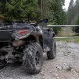 ATV oprit în fața unei bariere pe un drum forestier