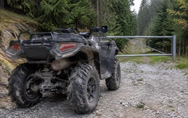 ATV oprit în fața unei bariere pe un drum forestier