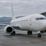 Avion alb fără însemne comerciale staționat pe o pistă de aeroport