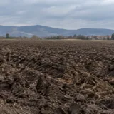 Un câmp arat din zona localității Șelimbăr aflat lângă dealuri