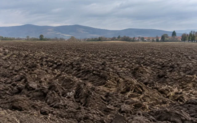 Un câmp arat din zona localității Șelimbăr aflat lângă dealuri