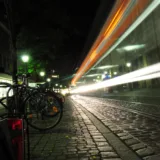 Biciclete parcate pe o stradă din oraș după lăsarea serii