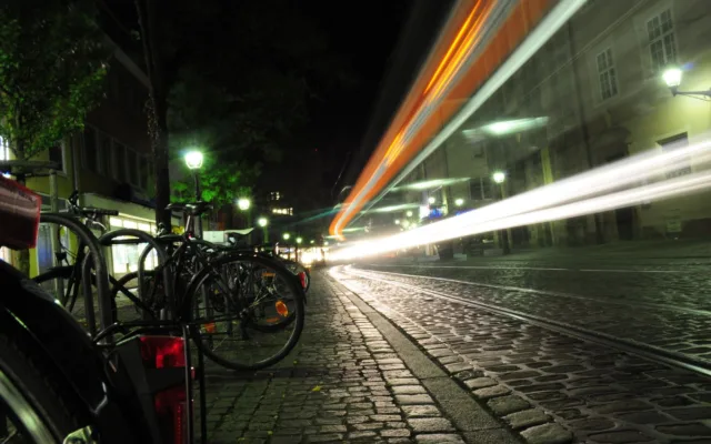 Biciclete parcate pe o stradă din oraș după lăsarea serii